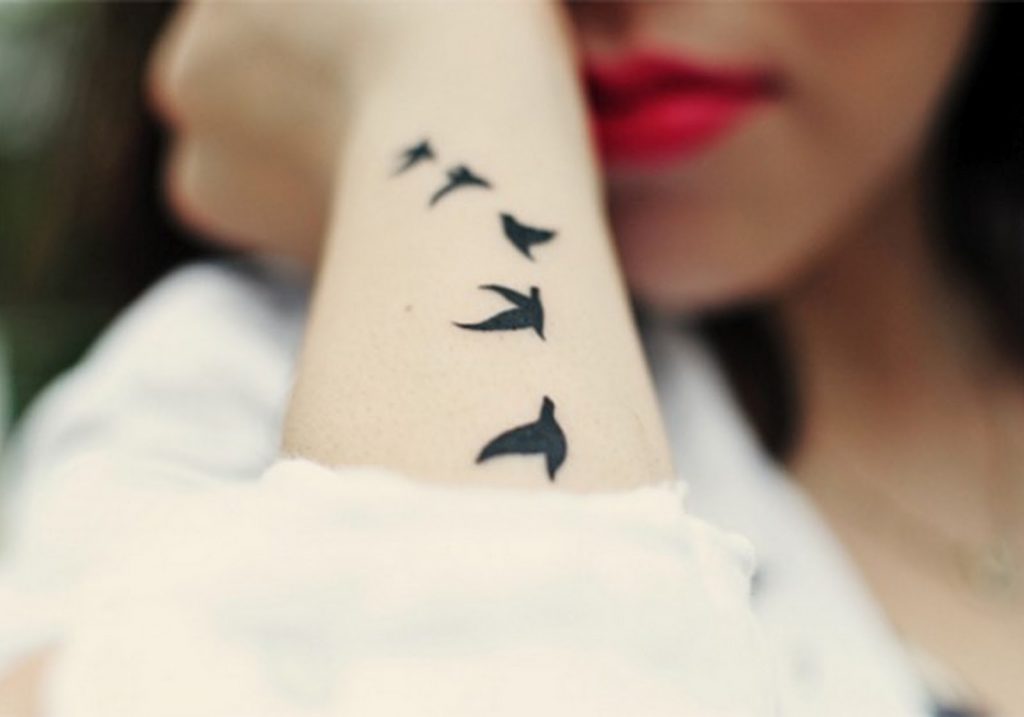 Tatuagem de pássaros no braço